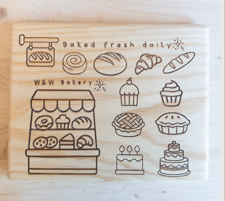 Wooden stamp with illustrations of bakery items and text 'Baked fresh daily' on a wooden background.